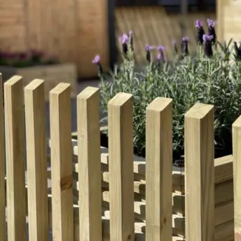 modern wooden fence with garden behind it