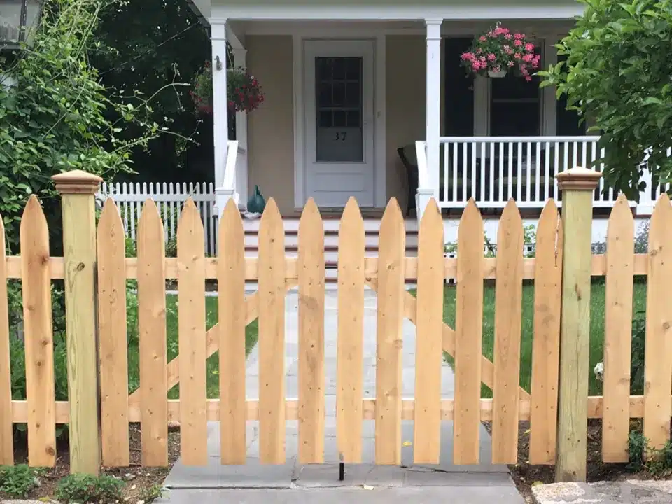 short picket fence unpainted in front of home