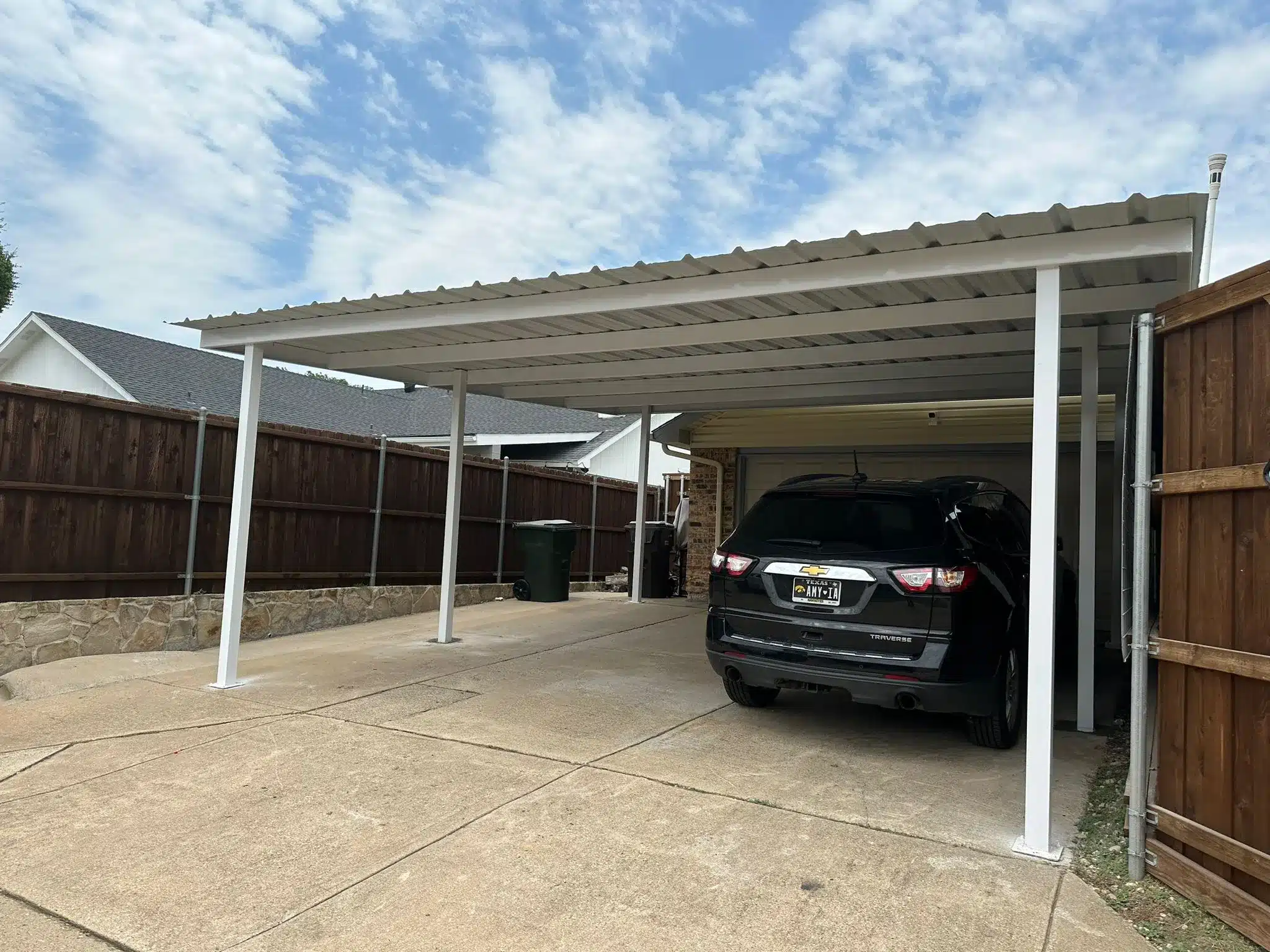 Steel carport frame sheltering a driveway