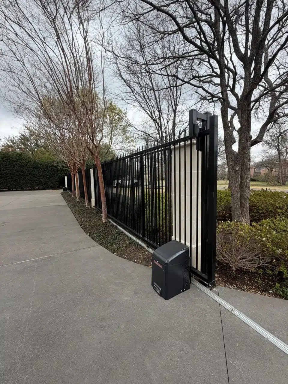 Eight-foot iron slide gate with a LiftMaster CSL24U operator beside the driveway
