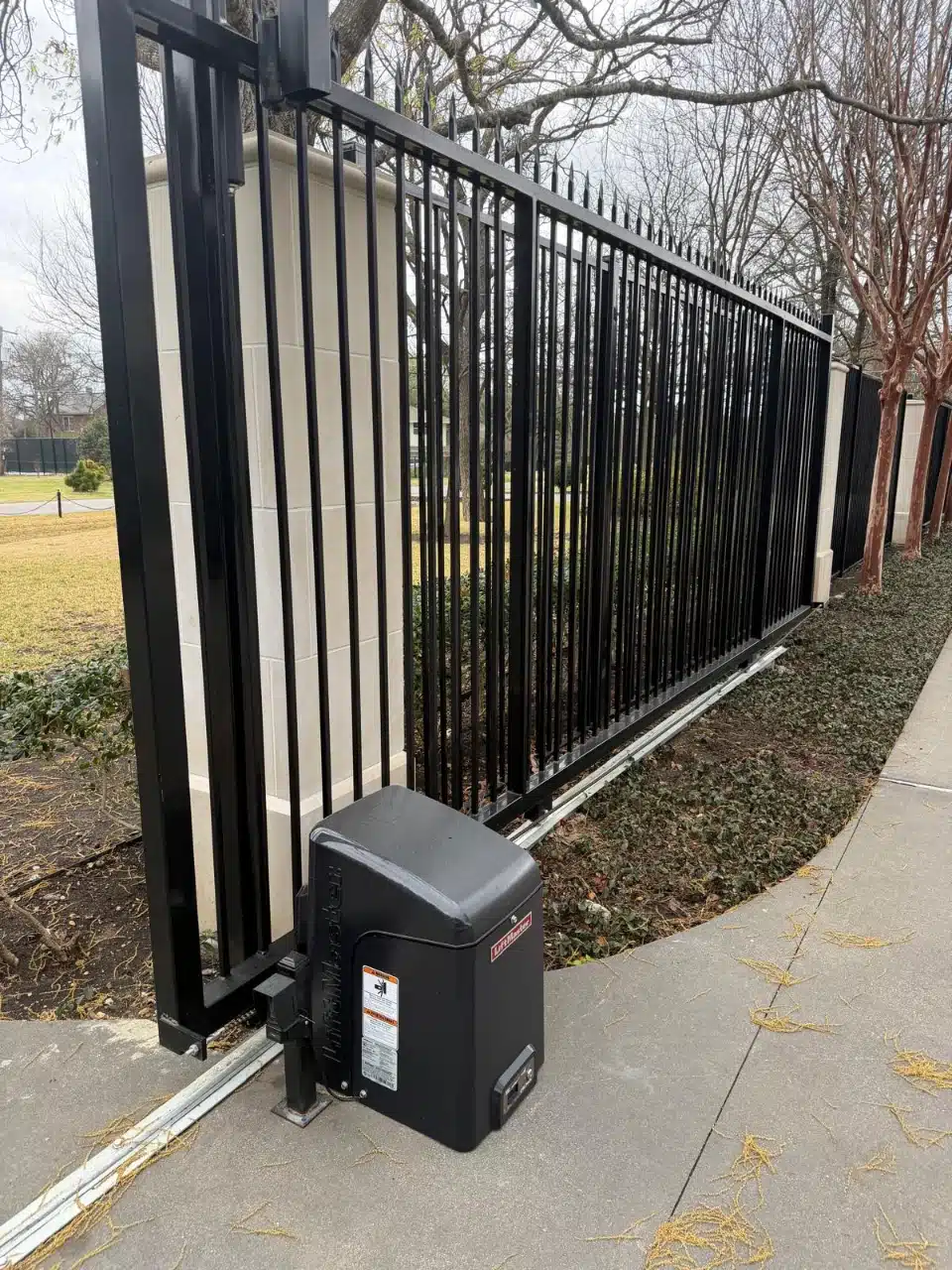 Iron slide gate running along the fence line on its ground track