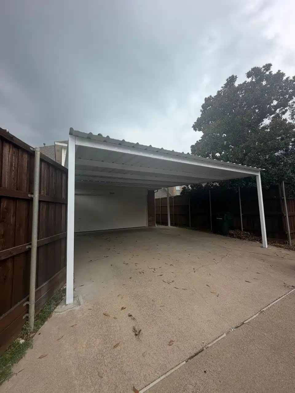 24 x 24 white steel carport built beside a home in Plano, Texas