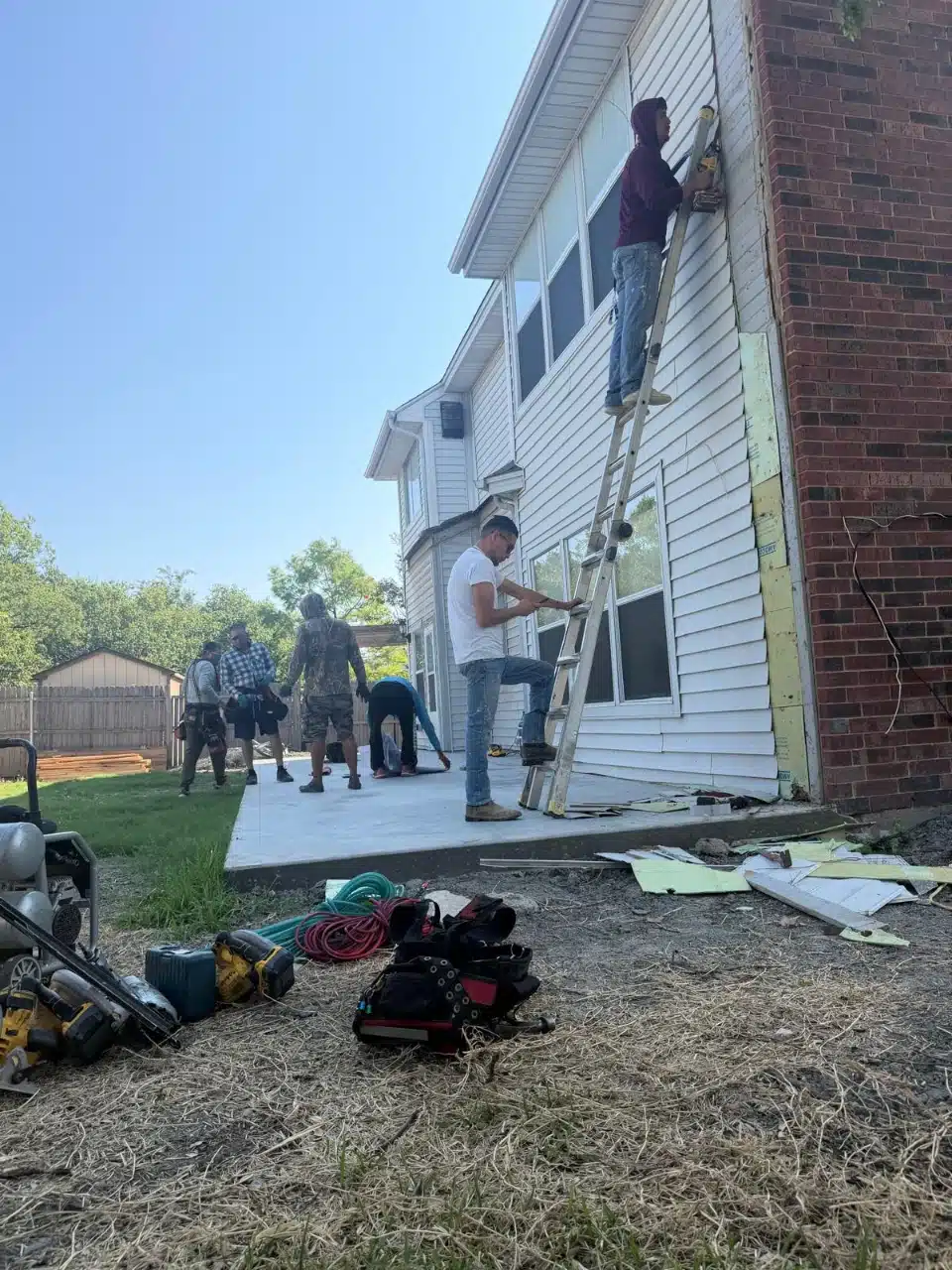 Technicians working at height on the existing exterior wall