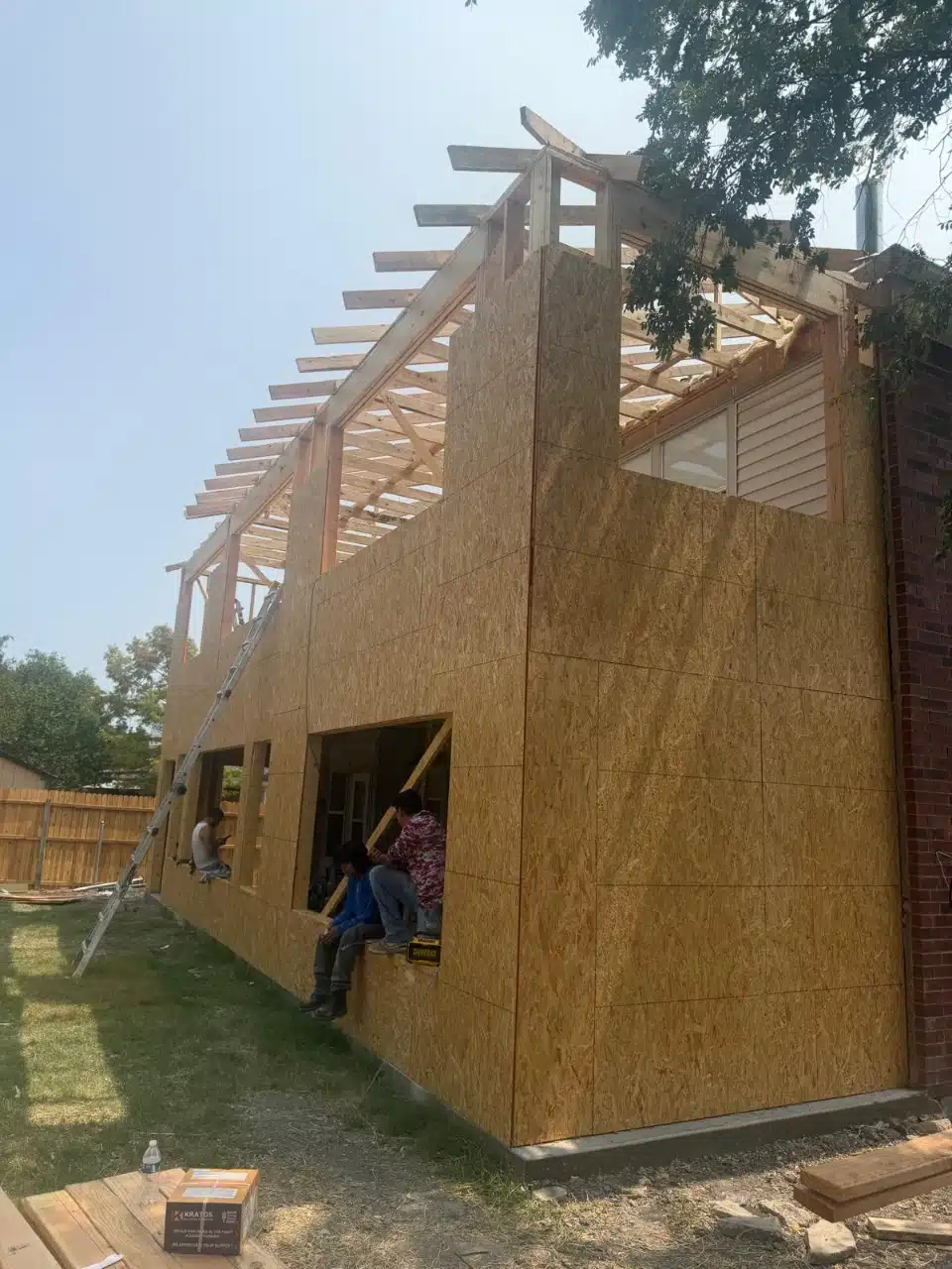 New home addition framed and sheathed beside the existing house