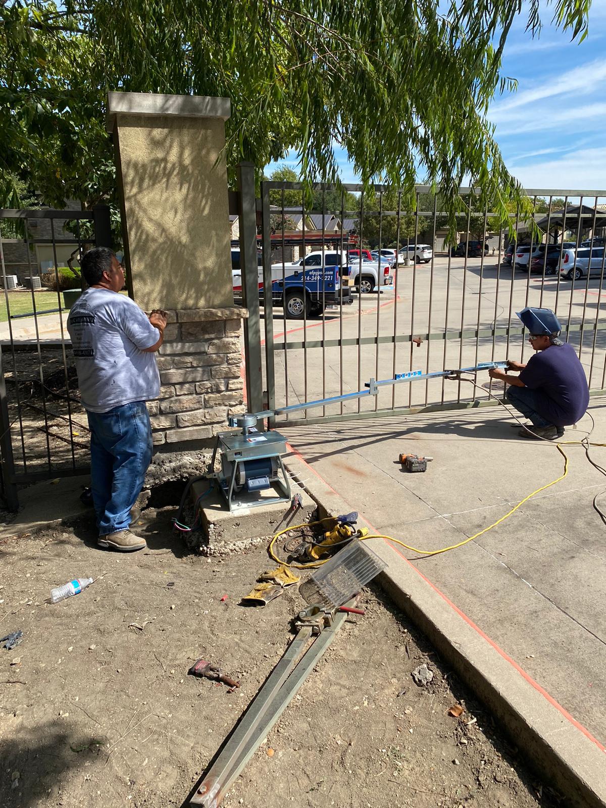 Crew working along the slide gate track at the property entrance