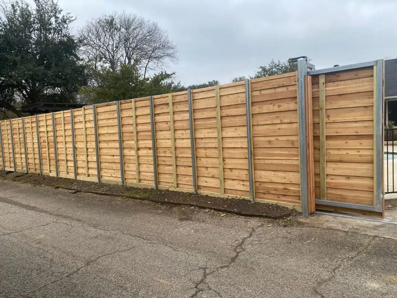 Horizontal cedar privacy fence running along a driveway in DFW