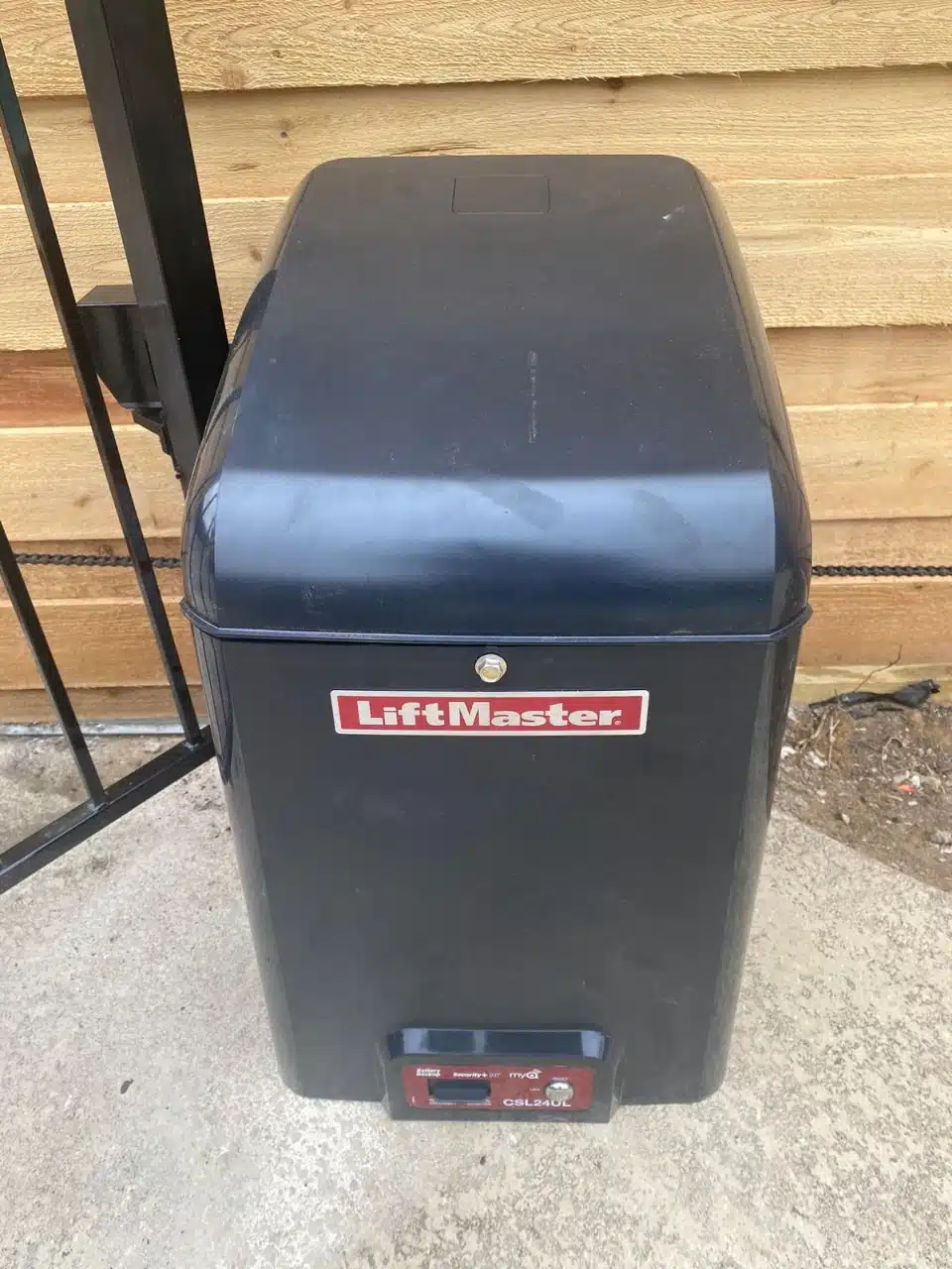 LiftMaster gate operator mounted behind the sliding cedar gate