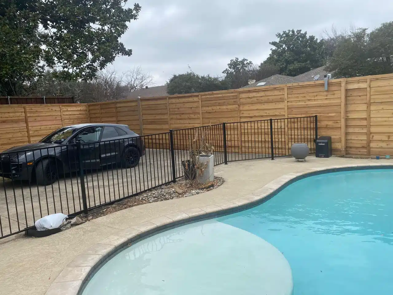 Iron pool fence with the cedar privacy run behind it