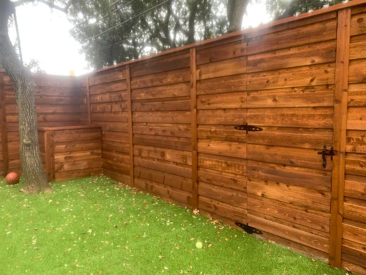 Horizontal cedar fence and matching gate seen from the yard