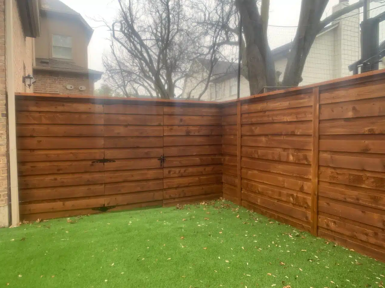 Corner of the horizontal cedar fence meeting at the rear of the yard