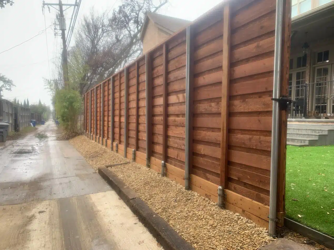 Cedar gate built into the horizontal fence run on the alley side