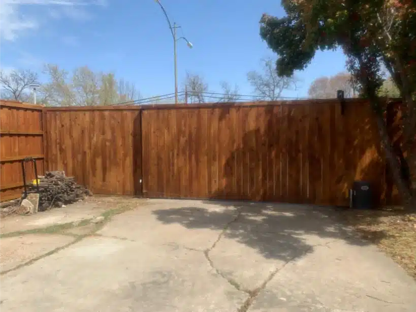 Sliding cedar gate closed across the driveway