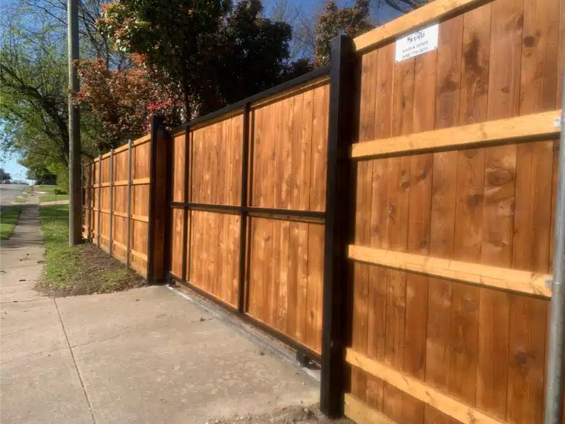 New cedar fence on steel posts running along the sidewalk
