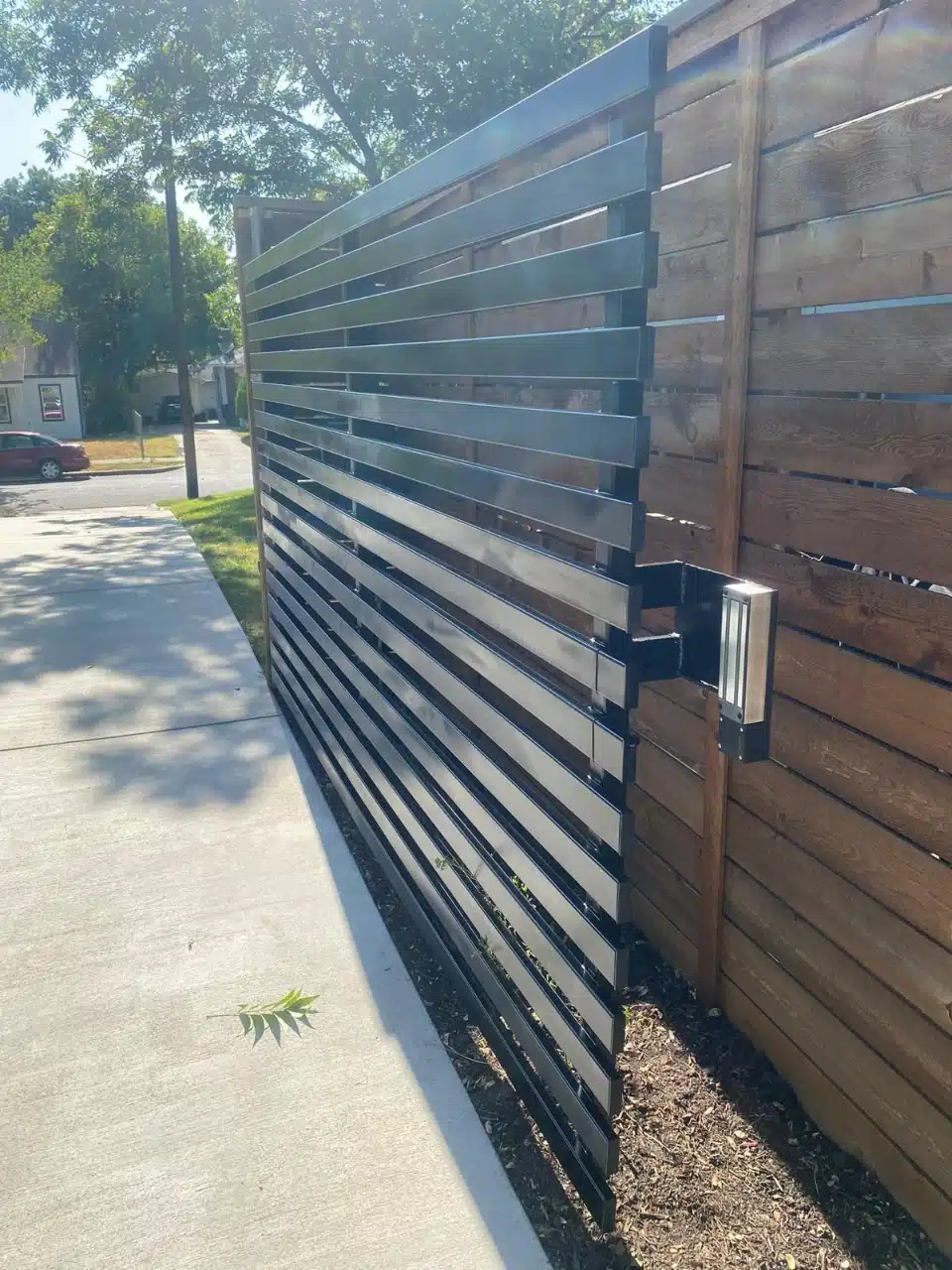 Horizontal slat steel gate closed across a residential driveway