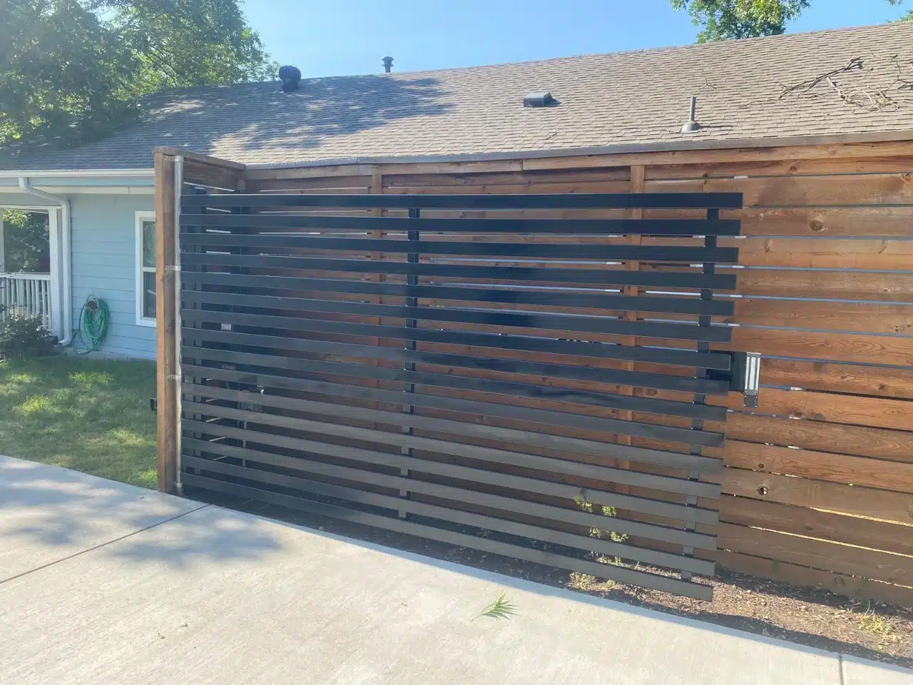 Steel slat gate set into the matching cedar fence line