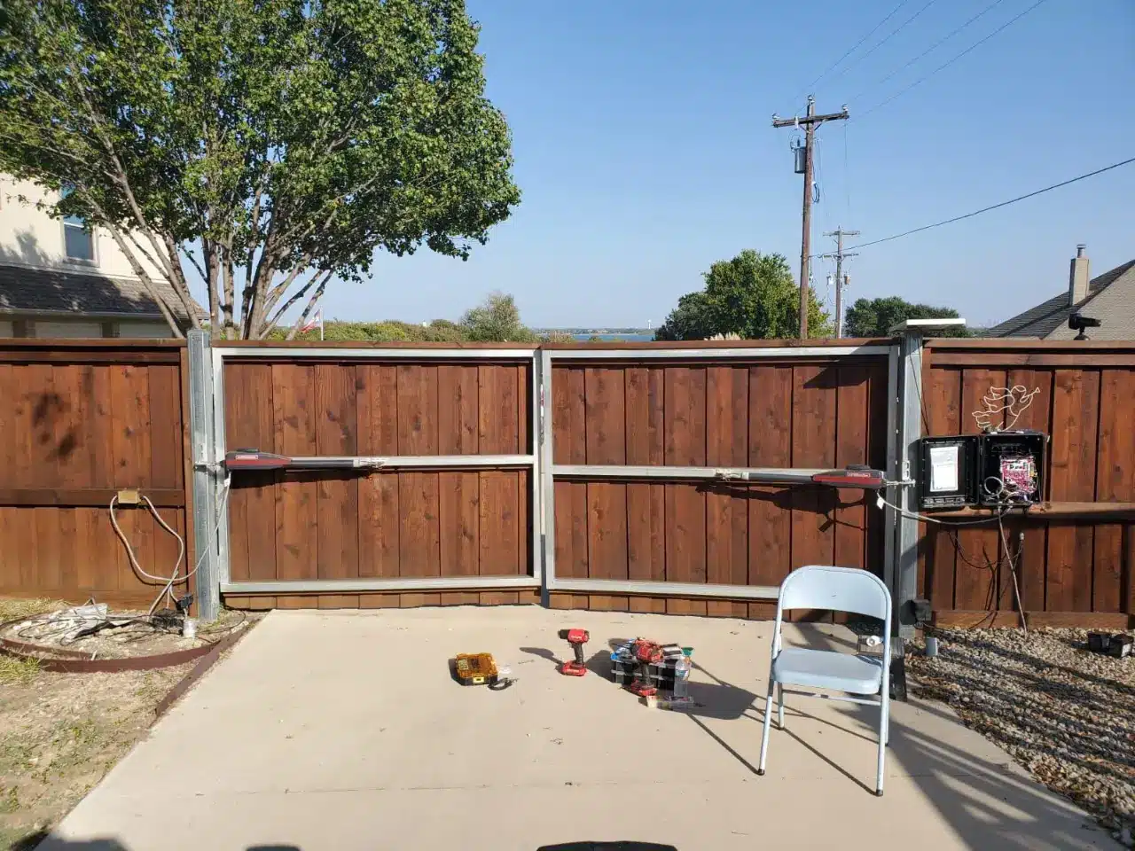 Concrete driveway with a wooden swing gate built for North Texas soil