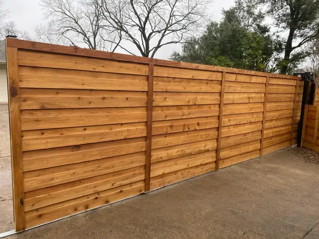 Installed horizontal wood fence with four panels separated by vertical supports