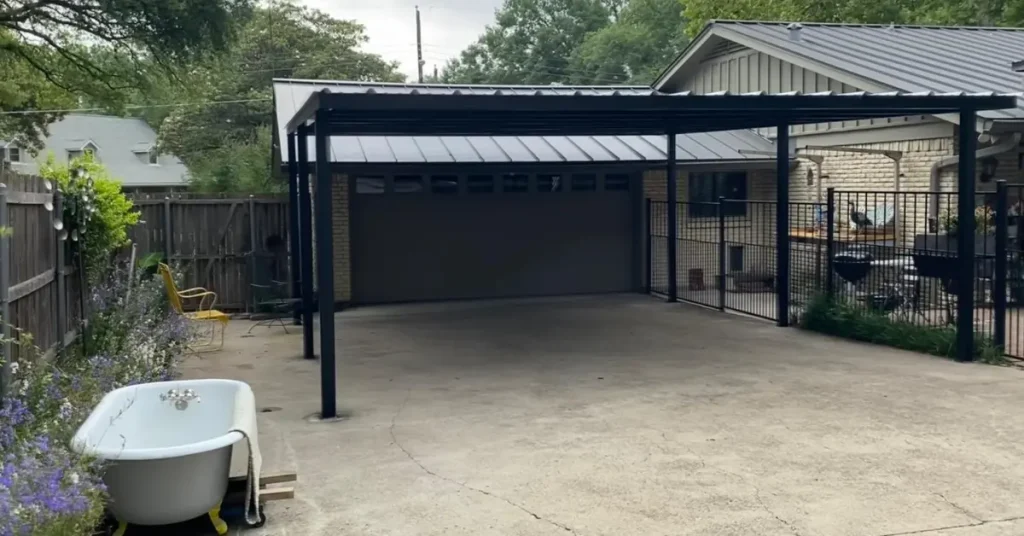 Newly installed black metal carport with steel roof and side fencing built by expert carport builders.